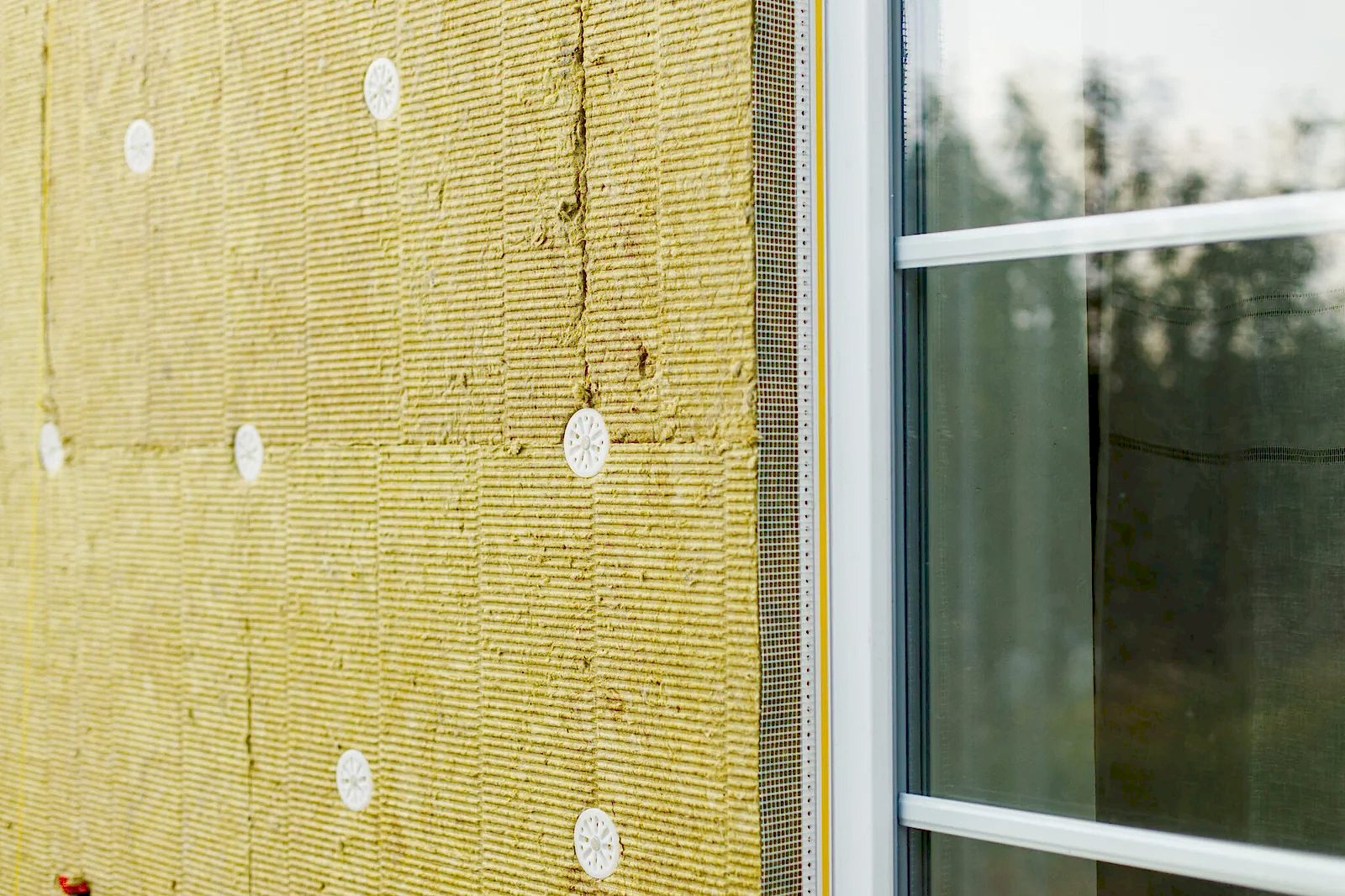 Facade insulation with mineral wool, thermal improvement and energy saving. Modern farmhouse renovation covering with stone wool panels close up. House insulation concept