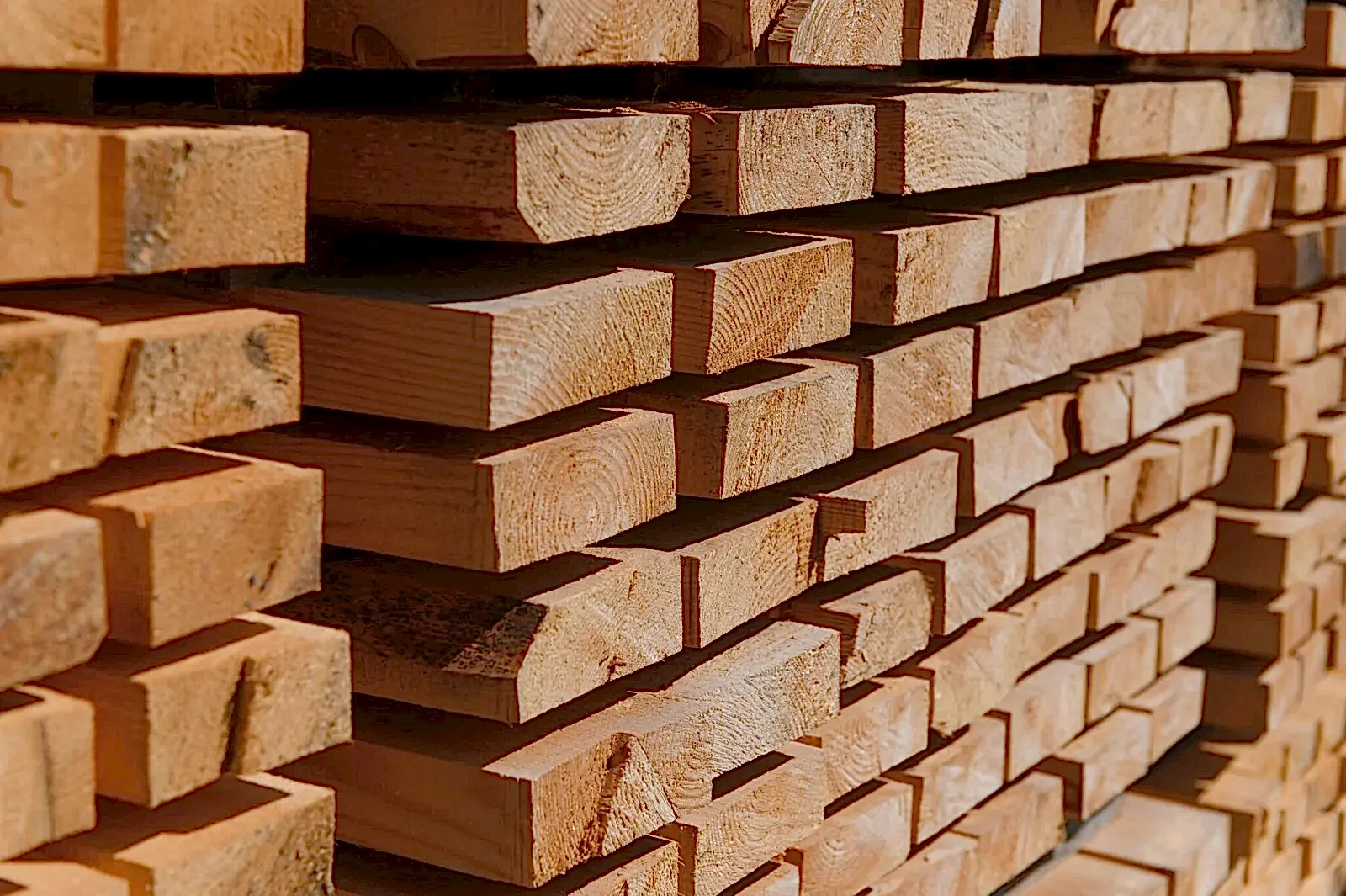 Stack of lumber of a wooden board from a tree, close-up, background. Wooden boards at the sawmill, carpentry workshop. Sawing and air drying of wood. Woodworking industry. Wooden boards.